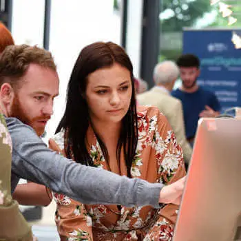 Brunel student showing a placement provider her final year project at the end of year show